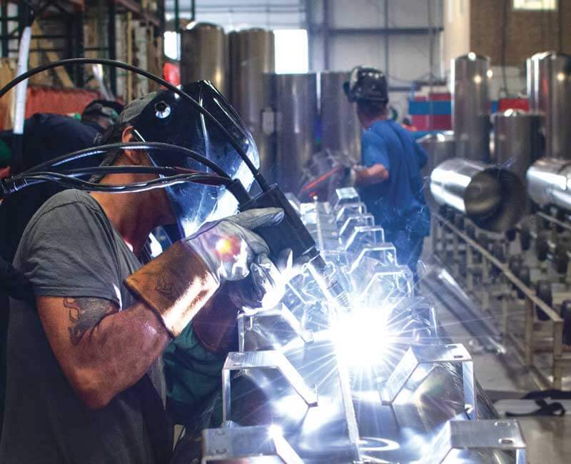 Workers welding tritoon tubes